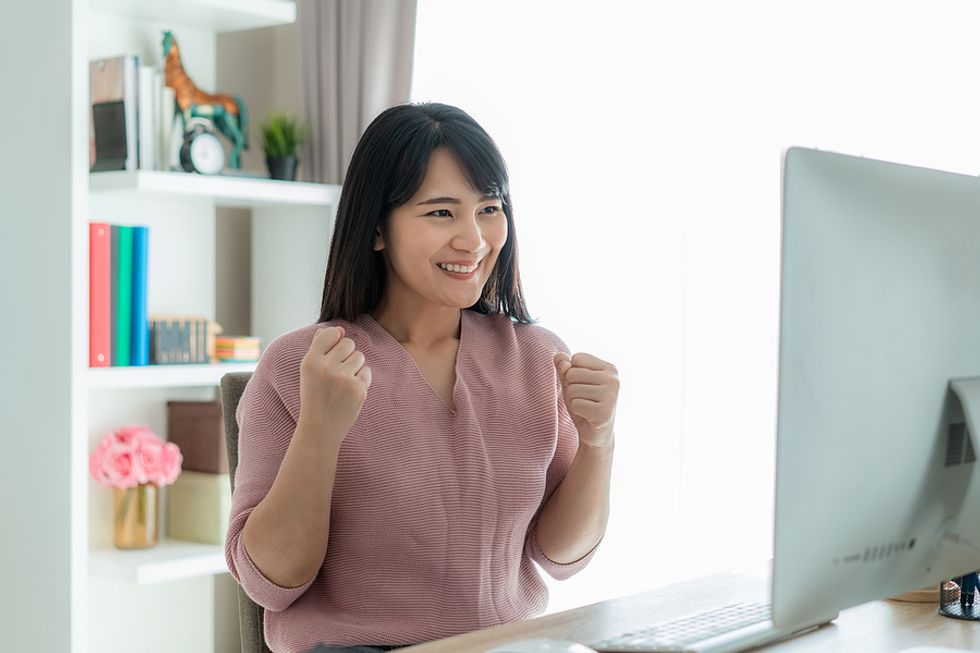 A business woman celebrates a small win after accomplishing a mini goal