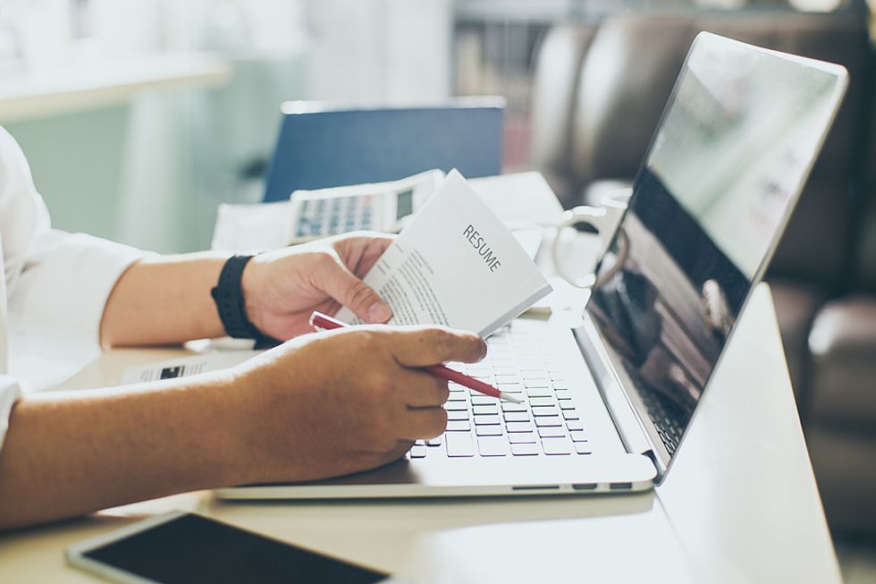 A businessman on his laptop makes edits to his resume