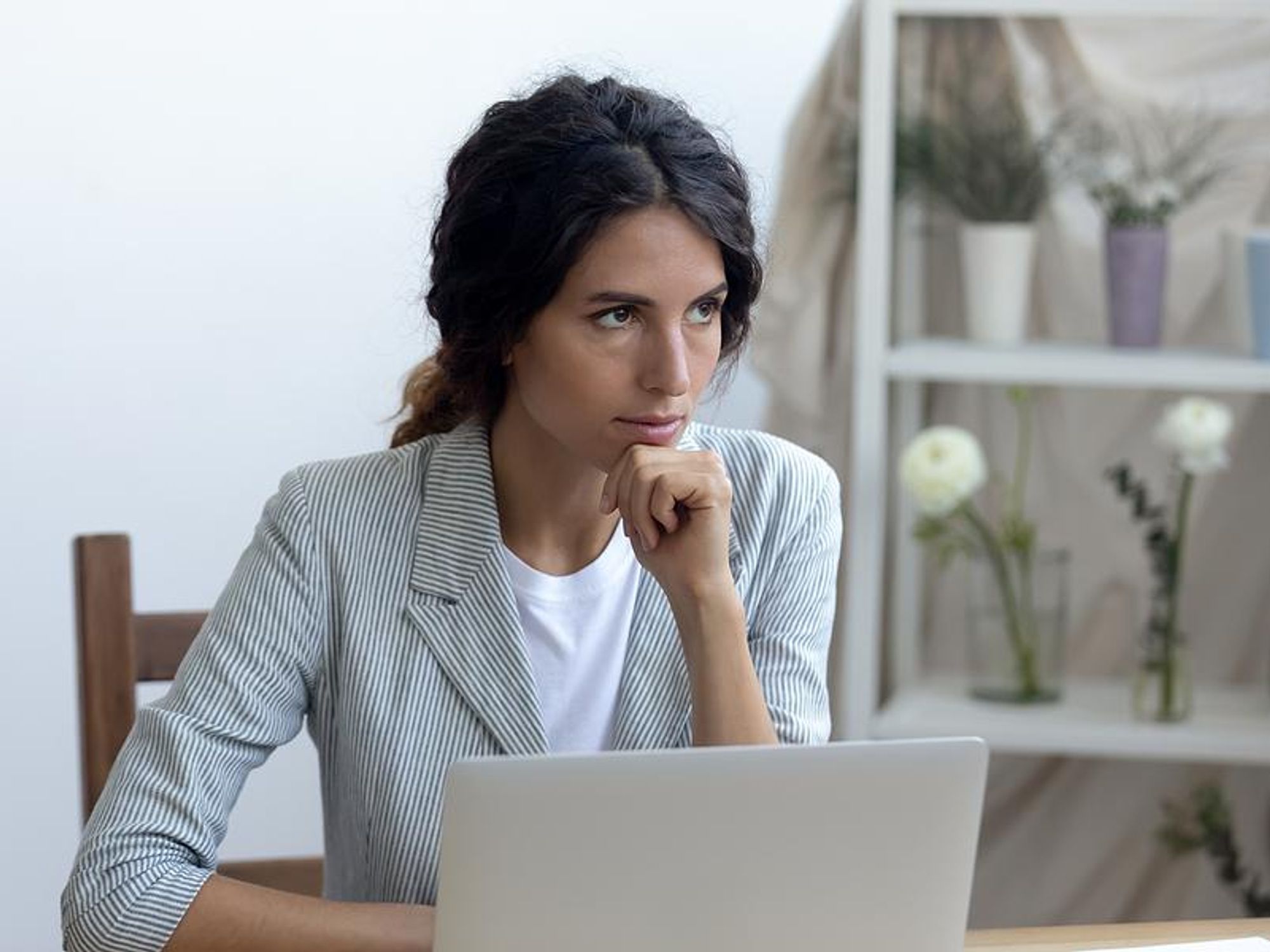 A businesswoman ponders whether or not she should follow-up on her job application.