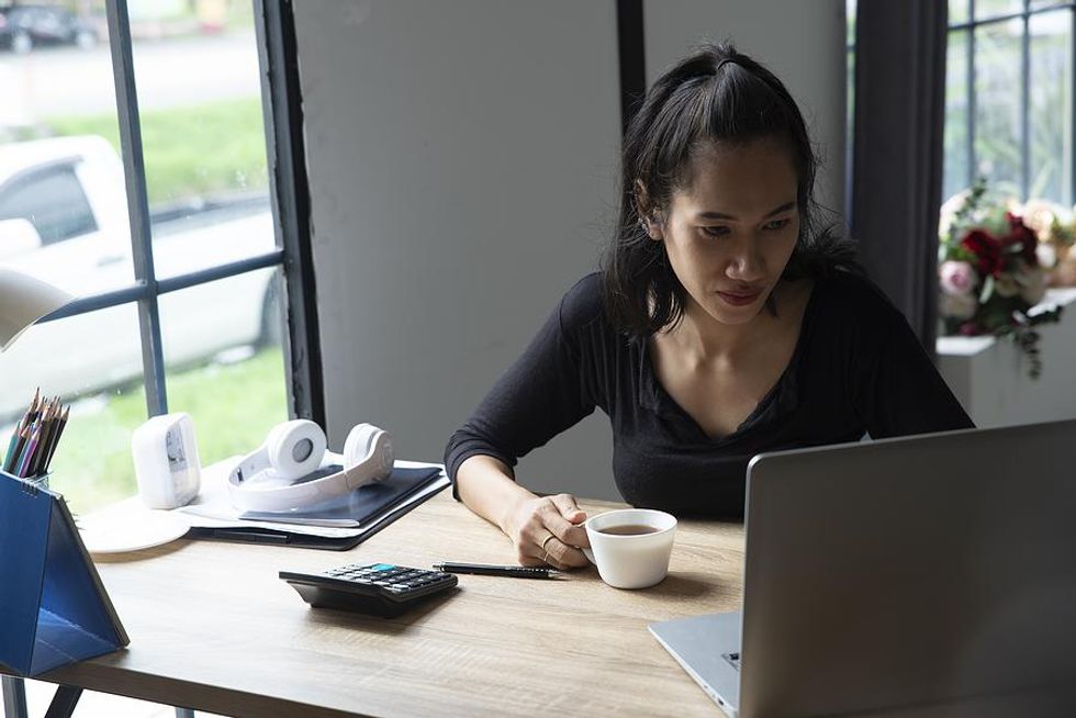 A businesswoman works with intense focus from her home office.