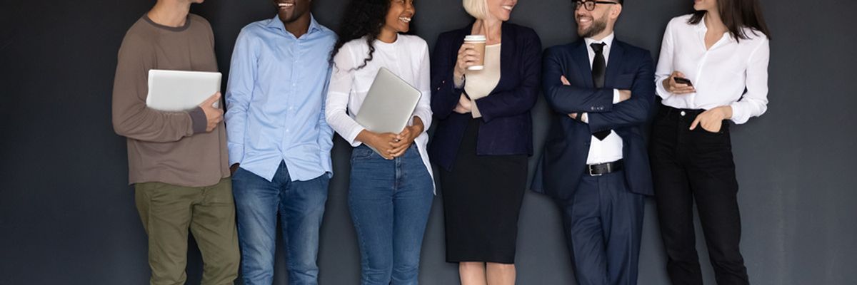 A diverse group of coworkers take a moment to chat and share laughs.