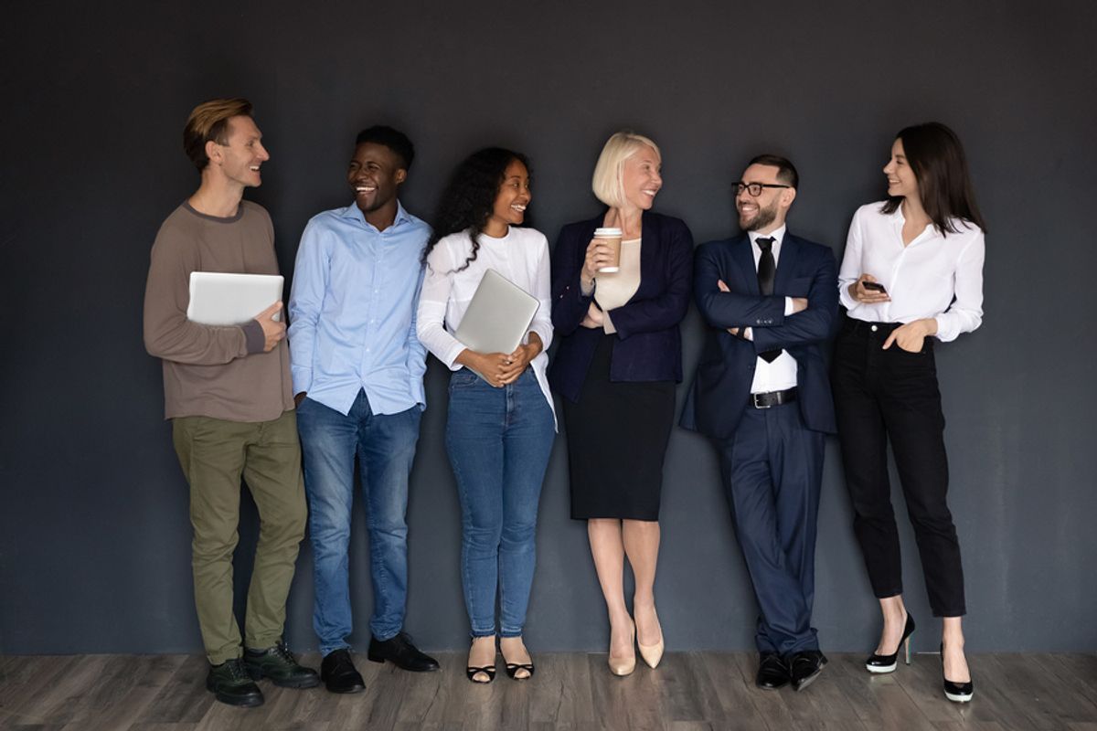 A diverse group of coworkers take a moment to chat and share laughs.