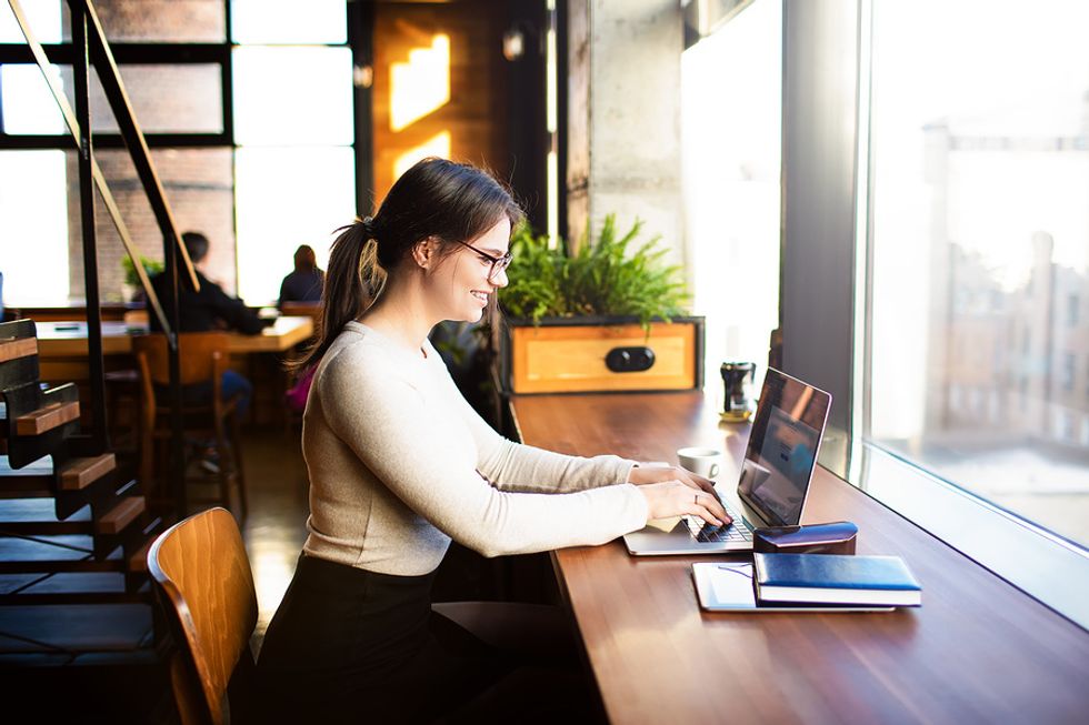 A freelance writer works on an assignment from a coffee shop.