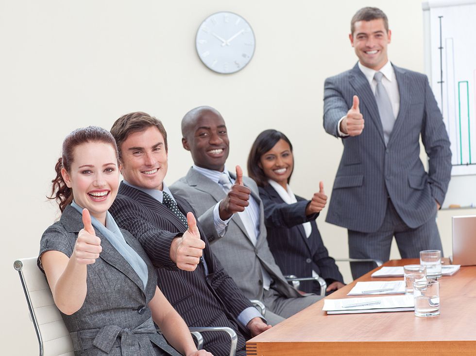 A group of employees give their company a thumbs up.