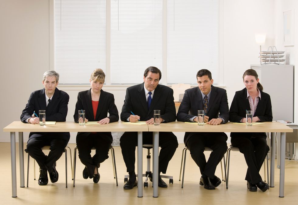 A group of professionals prepares to conduct a panel interview with job applicants
