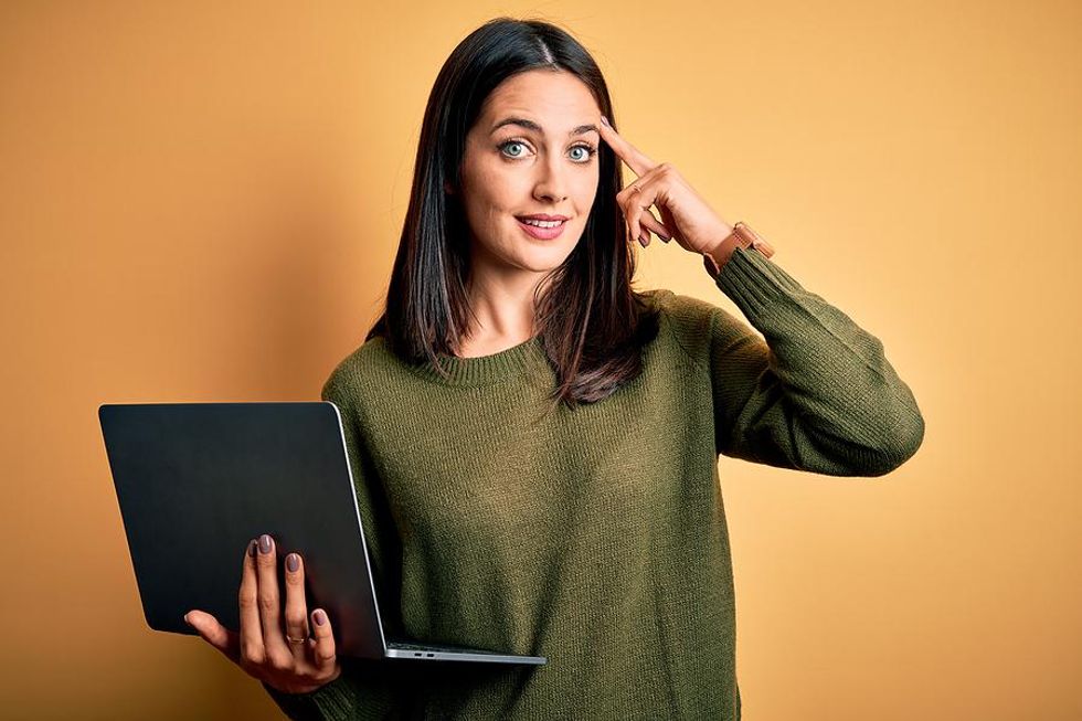 A job seeker holding her laptop gets a good idea about a follow-up email