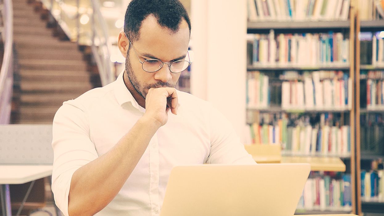 A job seeker on his laptop does his research on a company he wants to apply to