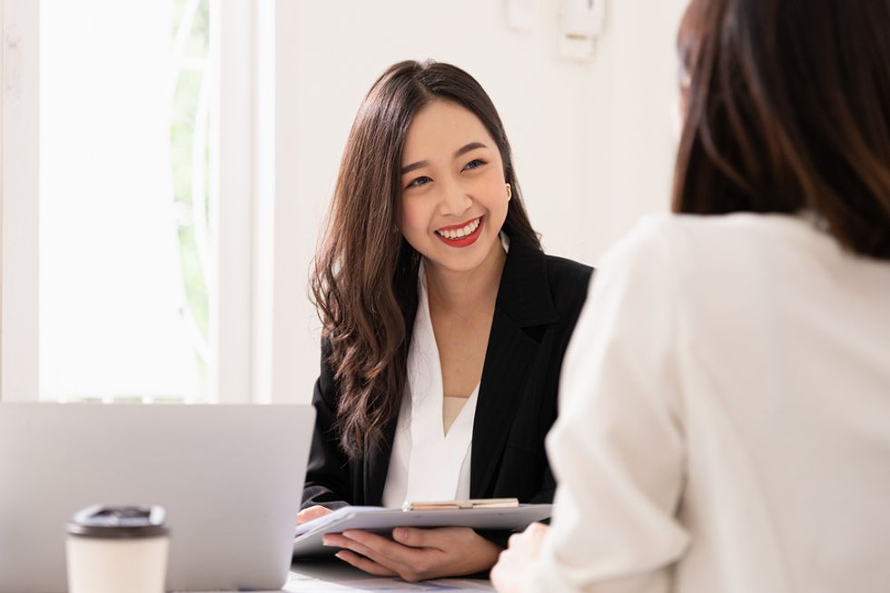 A job seeker smiles as she learns about the company's remote work options.