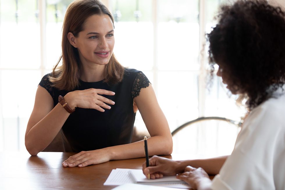 A manager takes notes on a candidate's questions.