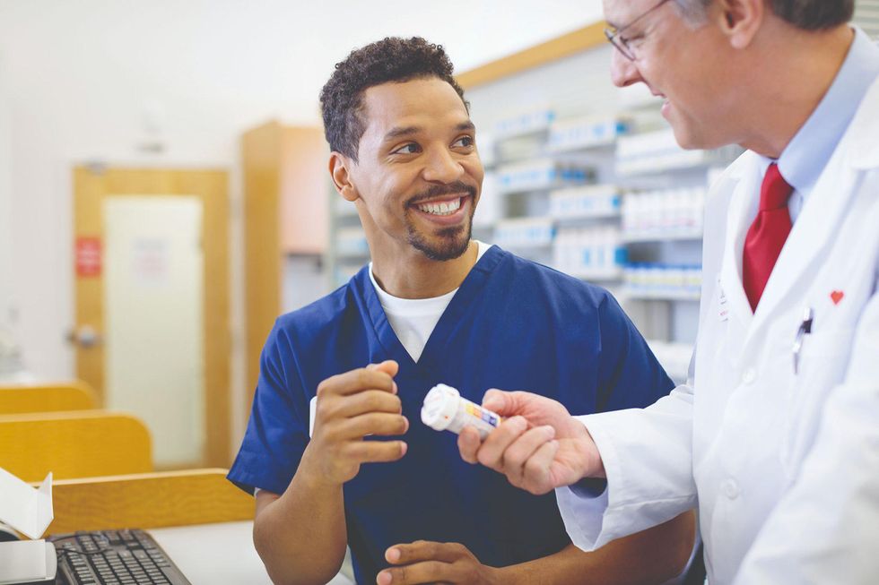 A pharmacy technicians chats with his boss.