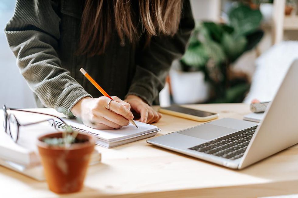 A professional writes down some notes while researching salary.