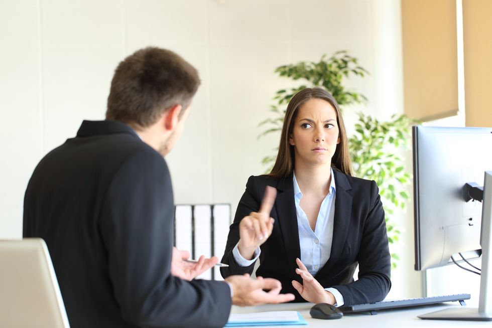 A recruiter stops a job seeker before he speaks during the interview.