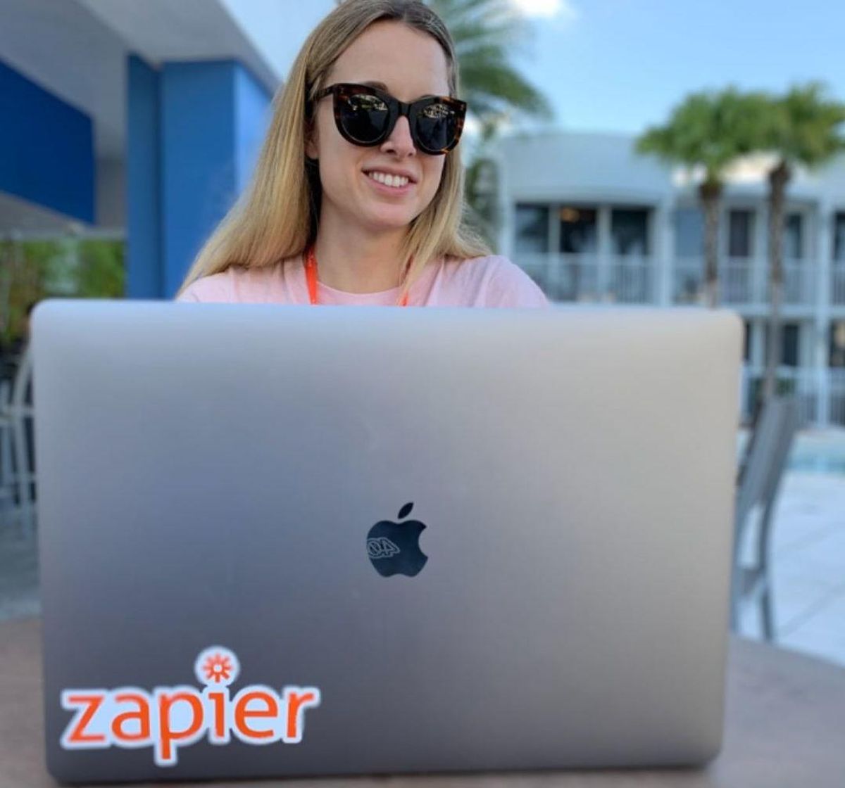 A remote worker at Zapier works poolside.