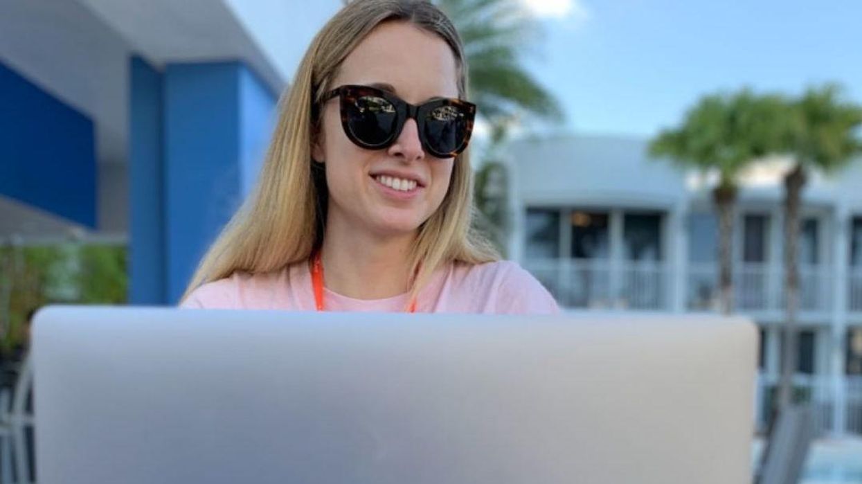 A remote worker at Zapier works poolside.