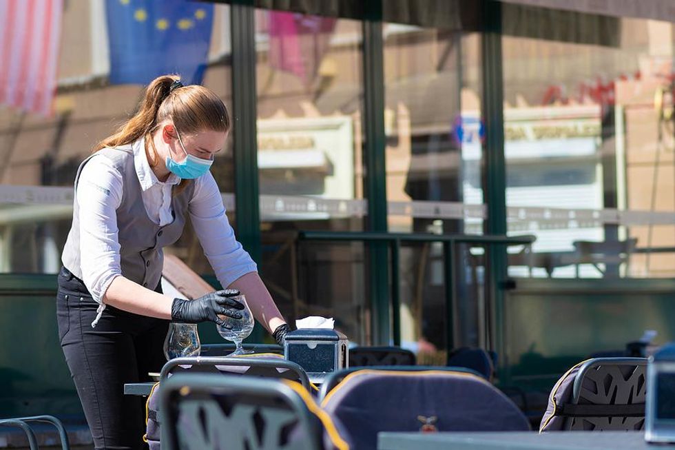 A restaurant worker clears a table.