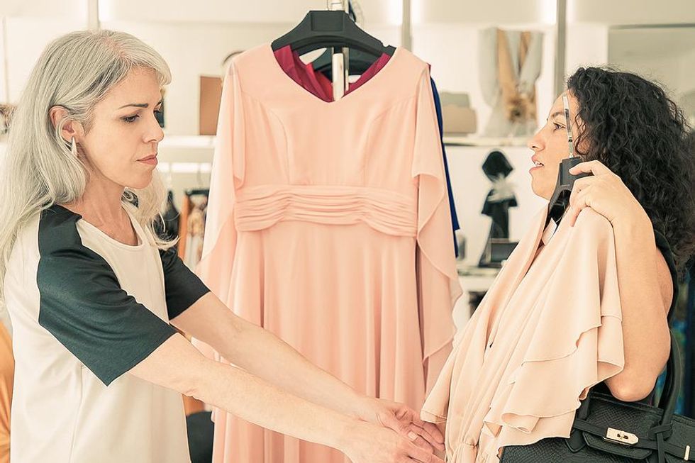 A retail associate helps a customer with a clothing question.