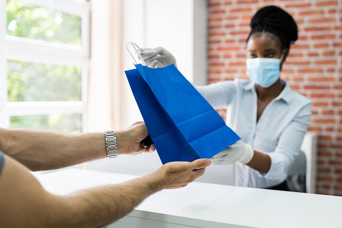 A retail cashier assists a customer with an order.