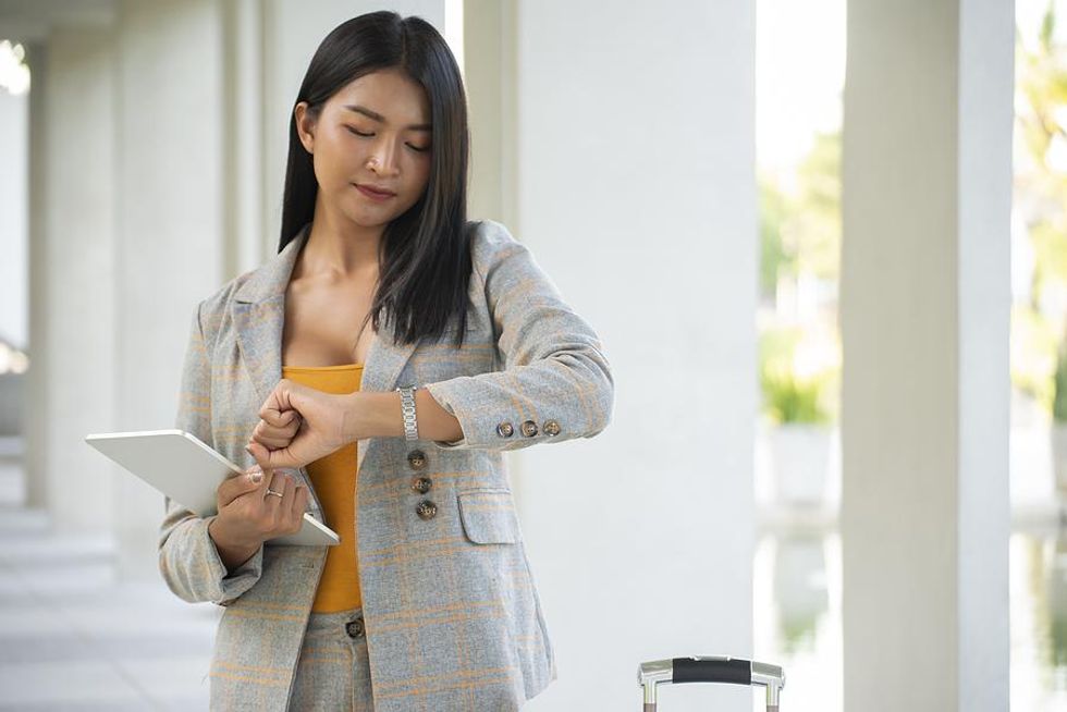 A self-starting intern looks at her watch at work