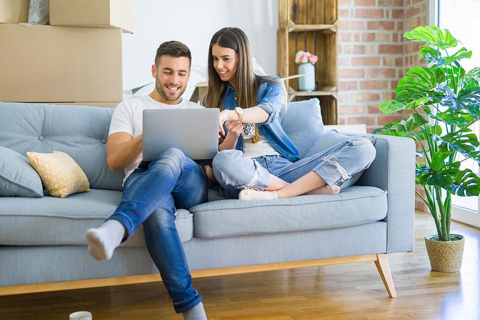 A woman helps her partner update his LinkedIn profile on his laptop