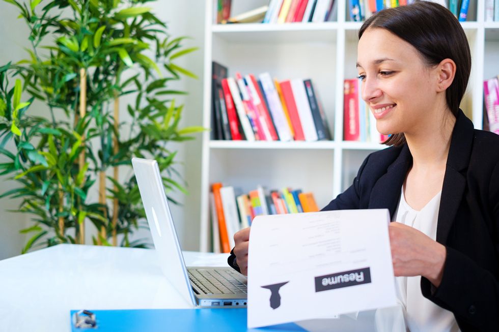 A young businesswoman considers uploading her resume to LinkedIn.