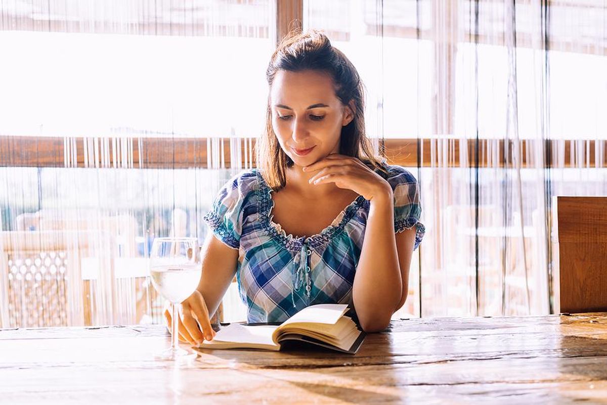 A young professional reads a book while on vacation.