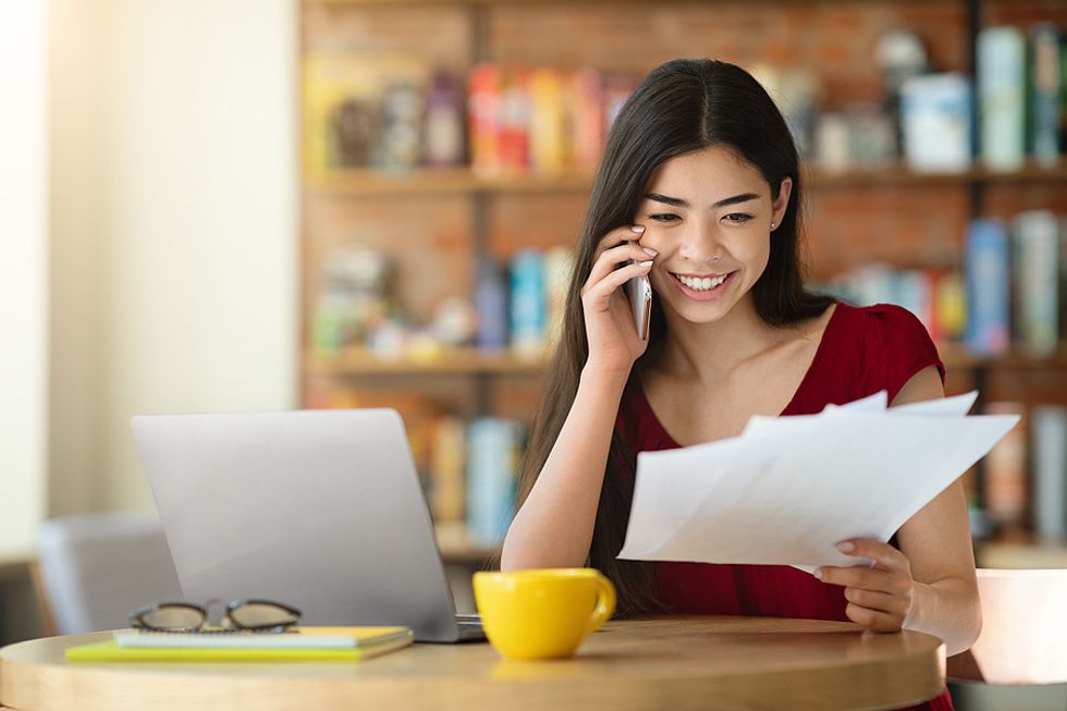 A young professional speaks to a client while working remotely.