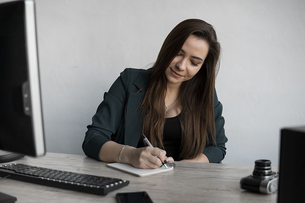 A young professional writes a few notes of appreciation for her employees