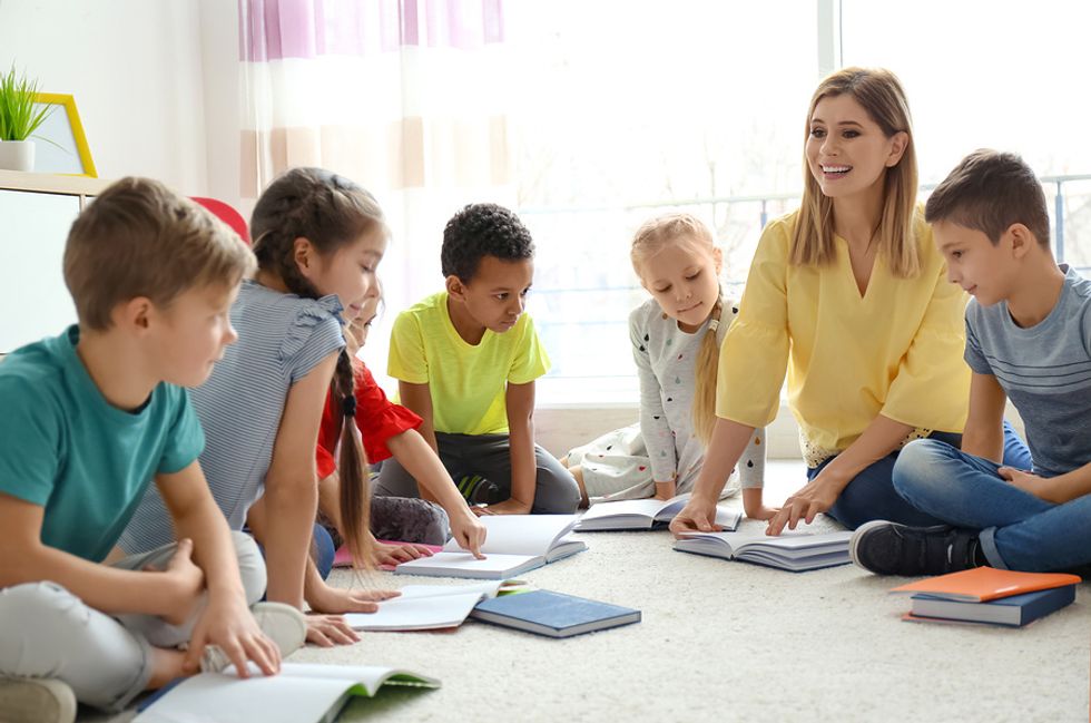 A young teacher is patient while answering a student's question