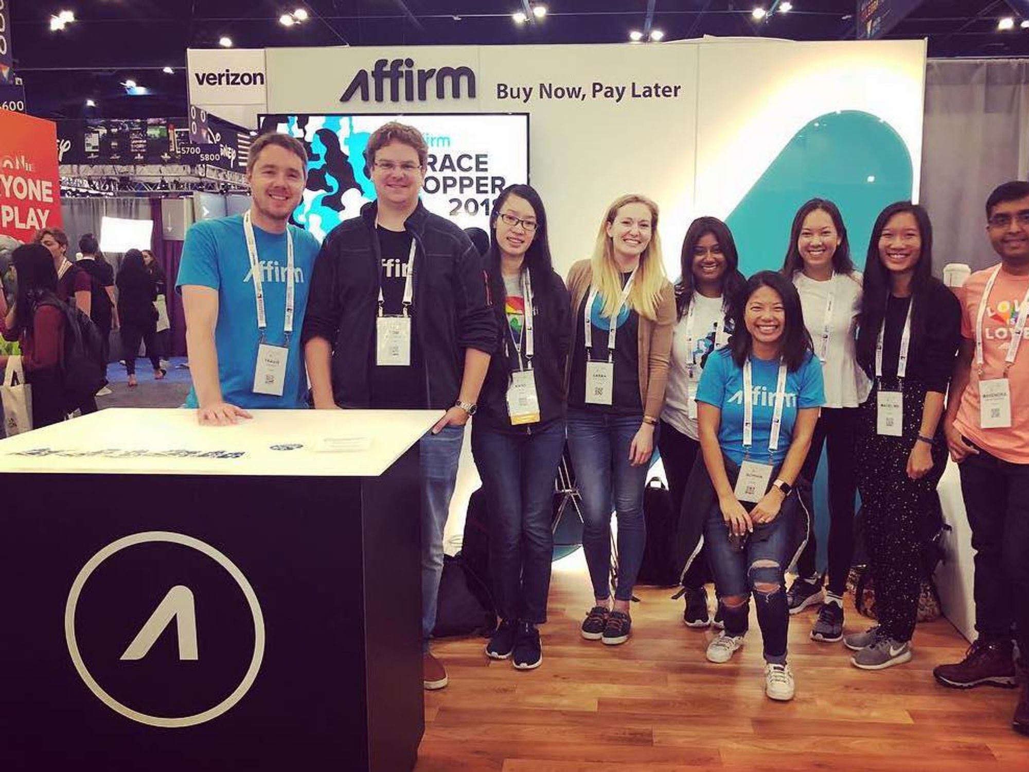 Affirm employees pose for a photo at a conference.