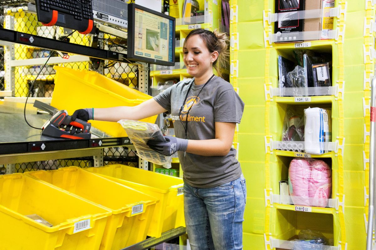 An Amazon warehouse worker fulfills an order.