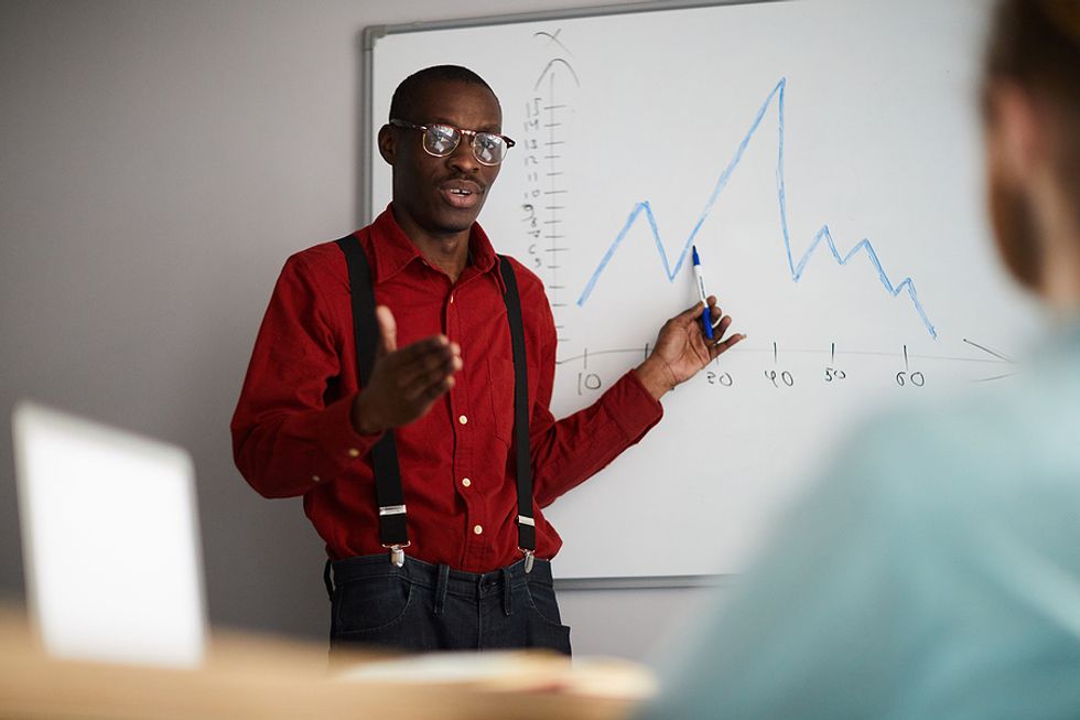 An employee graphs out an idea in front of his boss during a work meeting