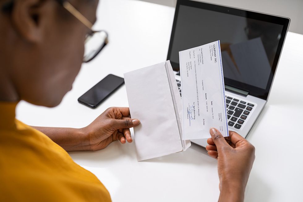 An employee looks over their paycheck after successfully negotiating a higher salary