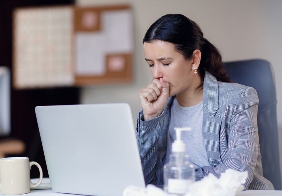 An employee with a cold continues to work in the office.