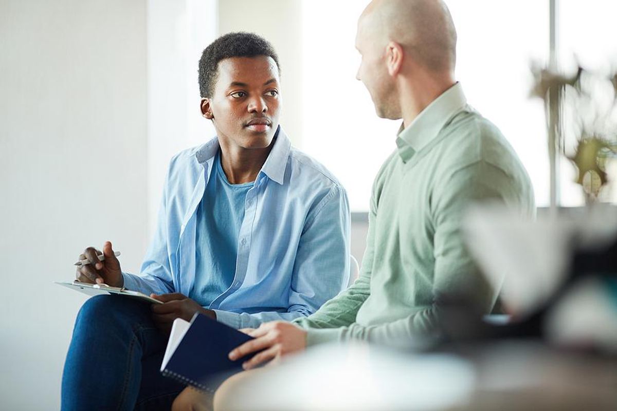 An intern meets with his supervisor at work