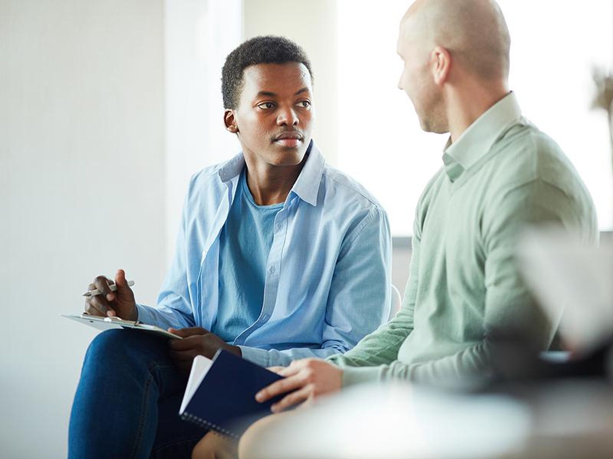 An intern meets with his supervisor at work