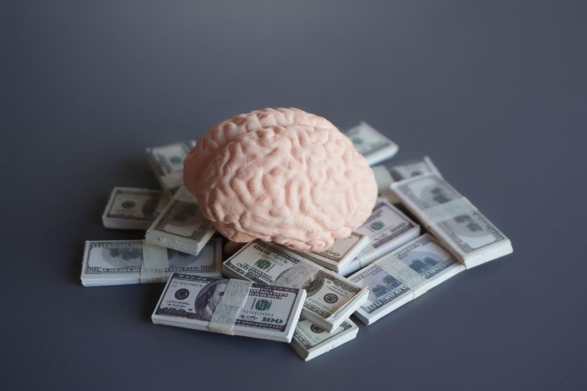 Brain on pile of money represents "monetize your mind" live event by Work It DAILY