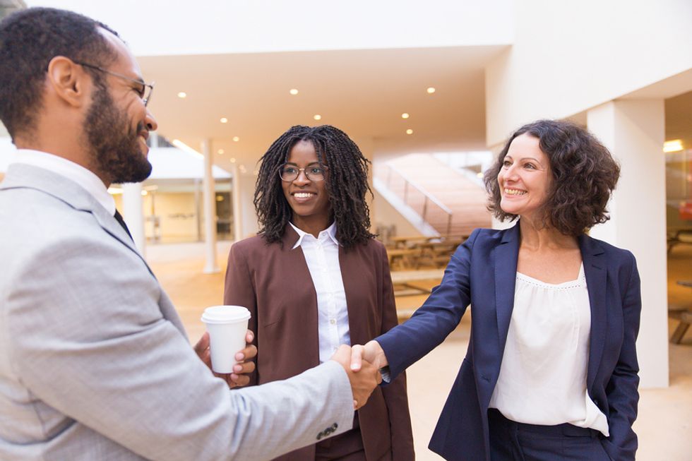 Business partners talk to a key stakeholder while meeting for coffee