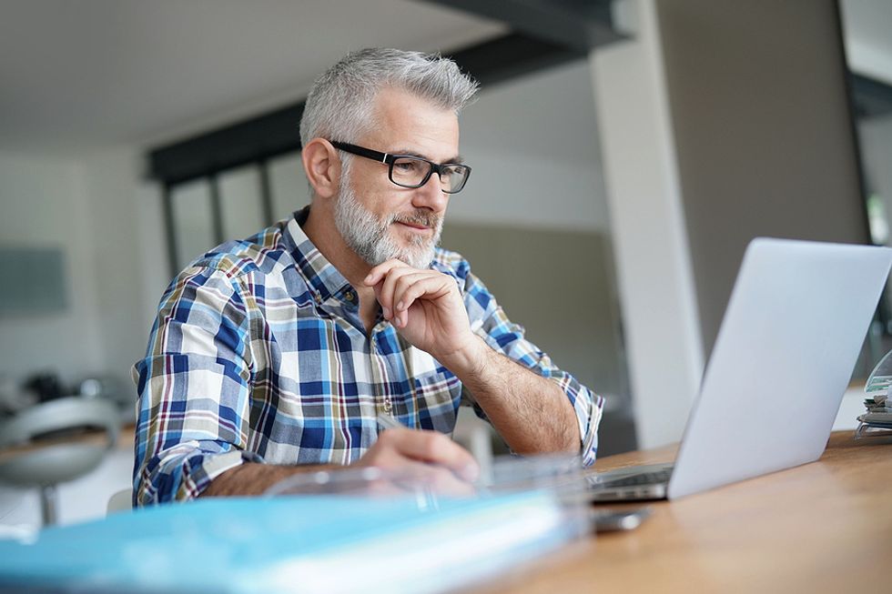 Businessman looks for a job on his laptop