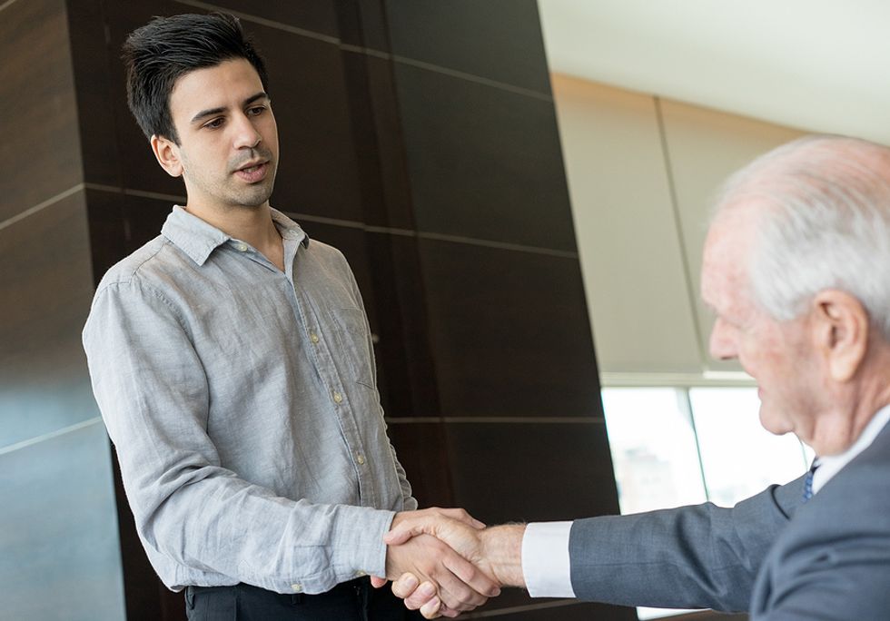 Businessman shakes hands with his boss after giving his resignation.