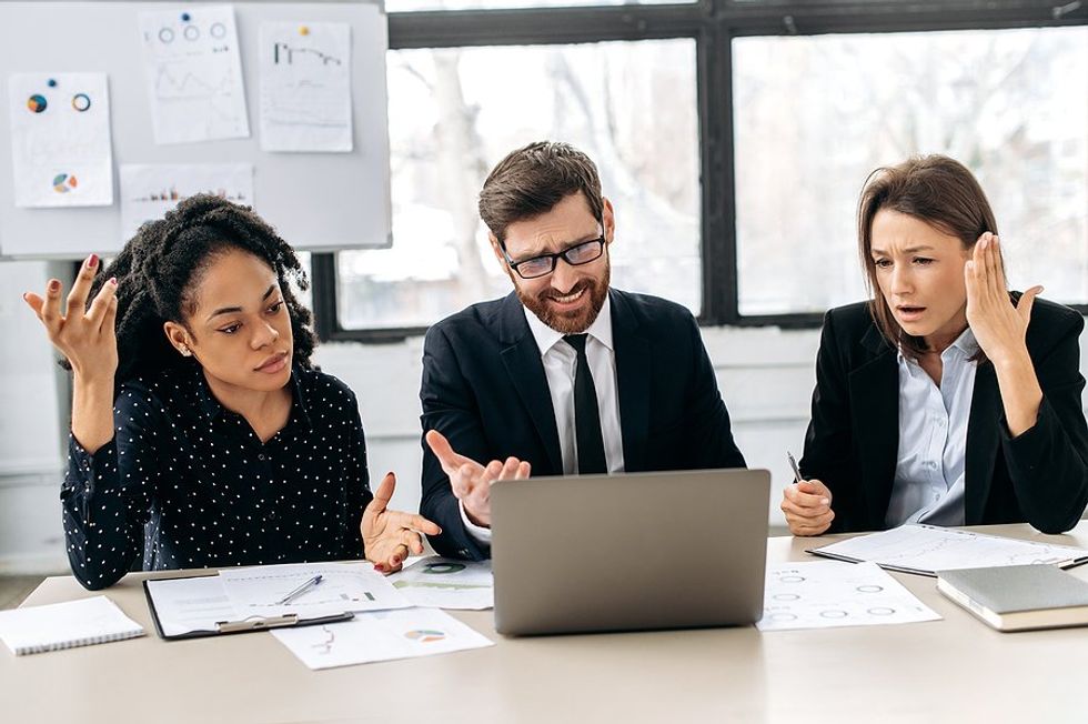 Businesspeople in a meeting upset about a failure at work