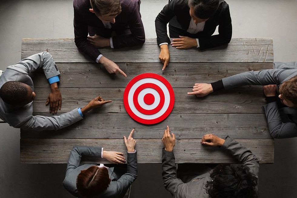 Businesspeople pointing at target taking about goals