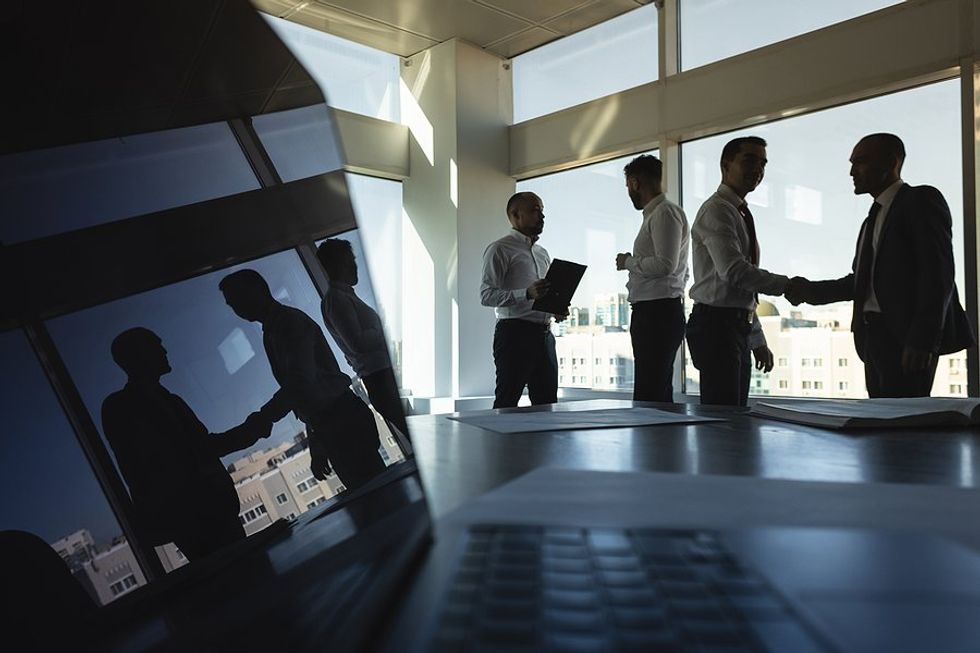 Businesspeople with good professional presence shake hands and talk during a work meeting