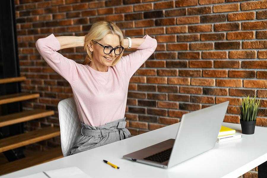 Businesswoman on laptop smiles after reading a recommendation that she received on LinkedIn