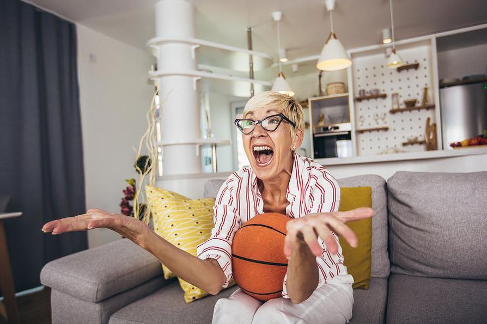 Businesswoman takes a break from work to watch basketball