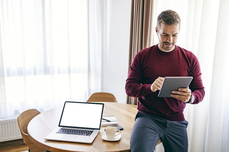 Busy executive on tablet stays up to date on trends