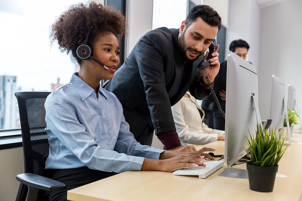 Call center employees help a customer