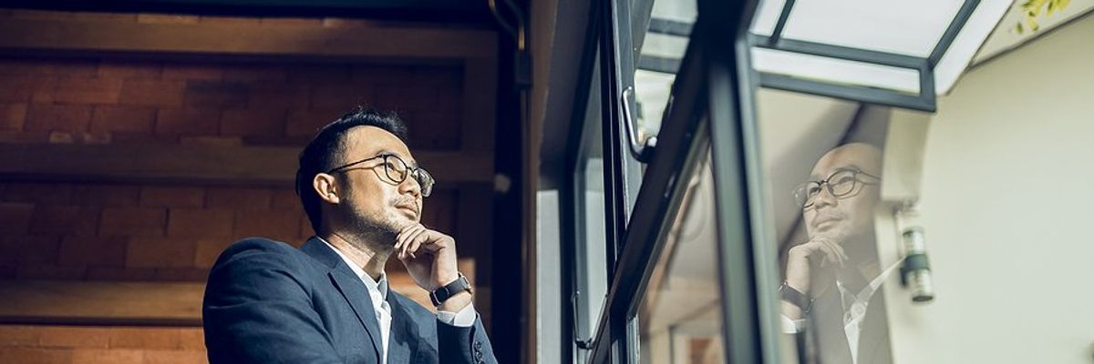 CEO/executive looks out the window while thinking about his business