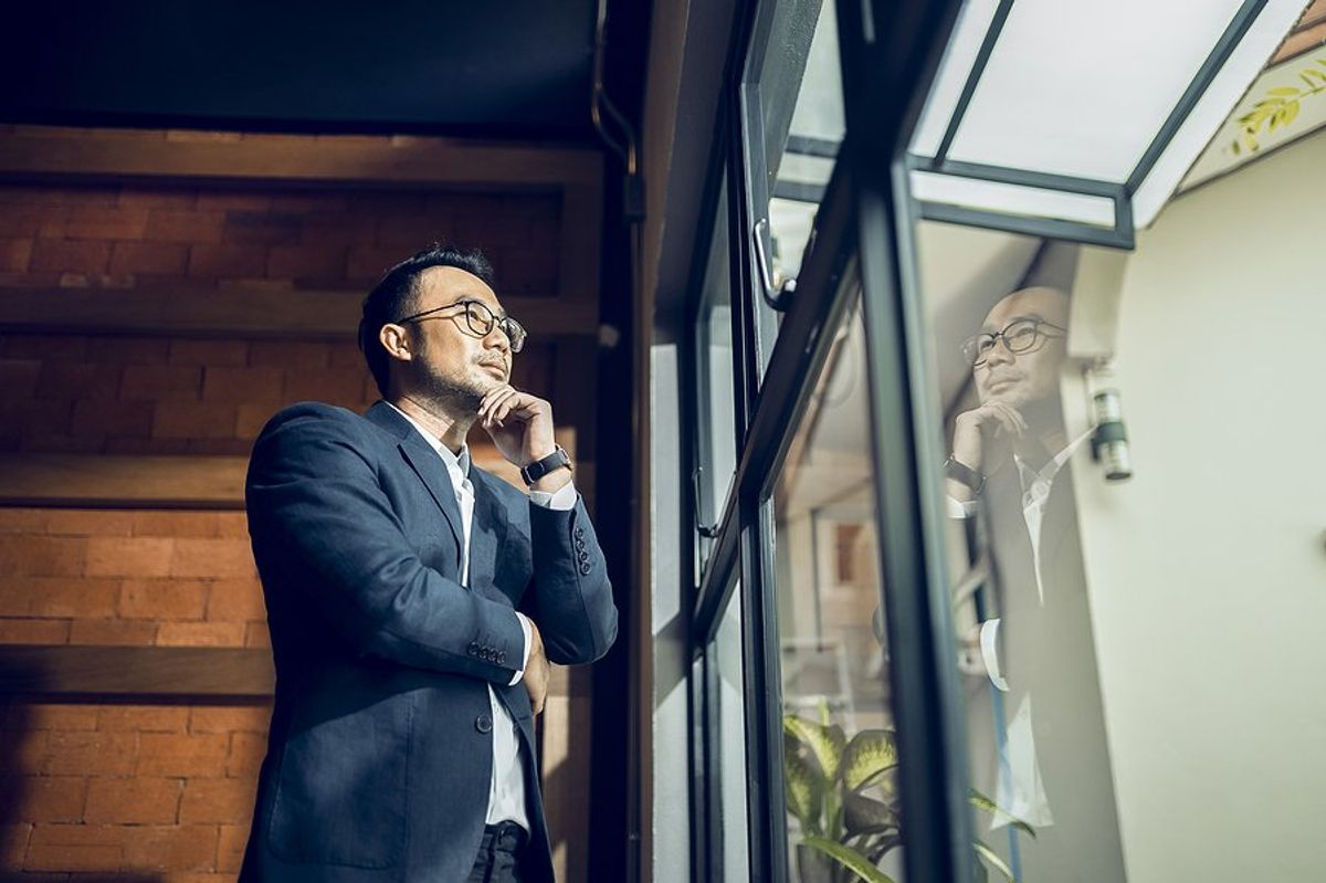 CEO/executive looks out the window while thinking about his business