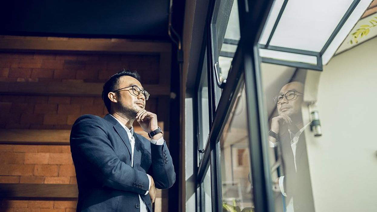 CEO/executive looks out the window while thinking about his business