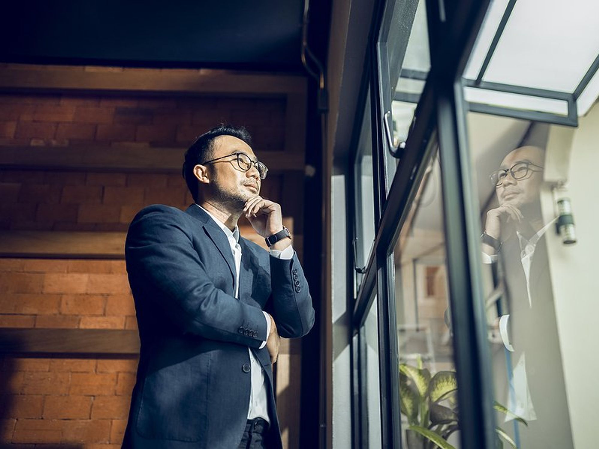 CEO/executive looks out the window while thinking about his business